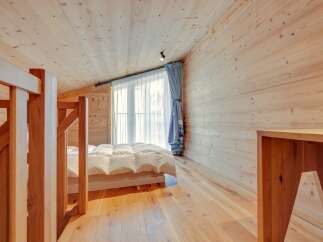 This cozy bedroom features a warm wooden interior, creating a serene and inviting atmosphere.