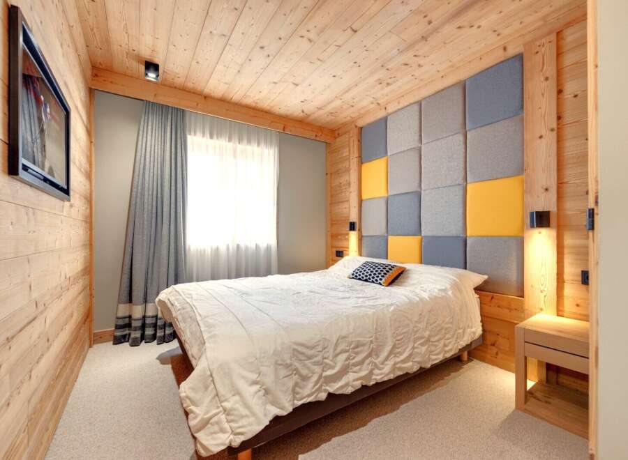 This cozy bedroom features a unique wooden paneling design, creating a warm and inviting atmosphere.
