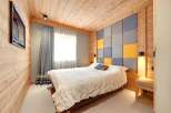 This cozy bedroom features a unique wooden paneling design, creating a warm and inviting atmosphere.