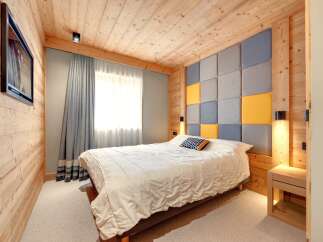 This cozy bedroom features a unique wooden paneling design, creating a warm and inviting atmosphere.