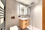 Step into a modern bathroom oasis! This stunning space features a sleek, floating wooden vanity with ample storage.