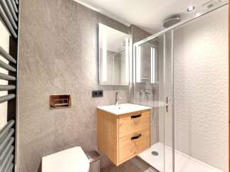 Step into a modern bathroom oasis! This stunning space features a sleek, floating wooden vanity with ample storage.