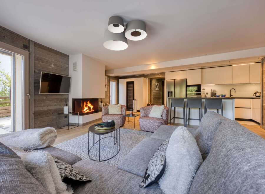 Experience luxury living in this stunning property, featuring a cozy living room with a fireplace and a modern kitchen.