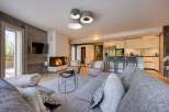 Experience luxury living in this stunning property, featuring a cozy living room with a fireplace and a modern kitchen.