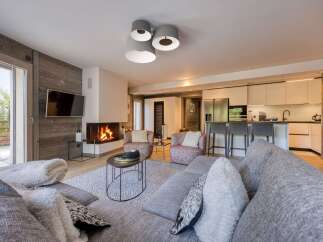 Experience luxury living in this stunning property, featuring a cozy living room with a fireplace and a modern kitchen.