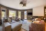 This stunning property boasts a cozy living room with a modern fireplace and a large sectional sofa, perfect for relaxing.