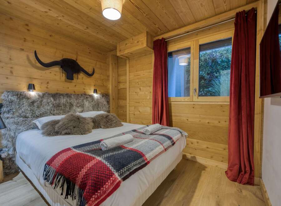This cozy bedroom features a rustic wooden interior, creating a warm and inviting atmosphere.