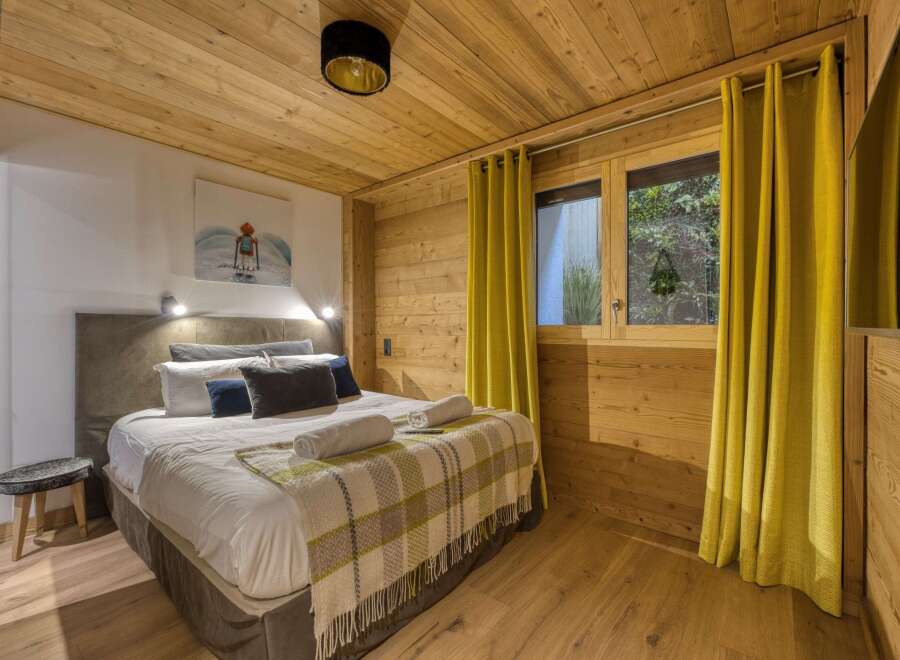 This cozy bedroom features a warm wooden interior, creating a rustic and inviting atmosphere.