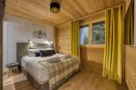 This cozy bedroom features a warm wooden interior, creating a rustic and inviting atmosphere.