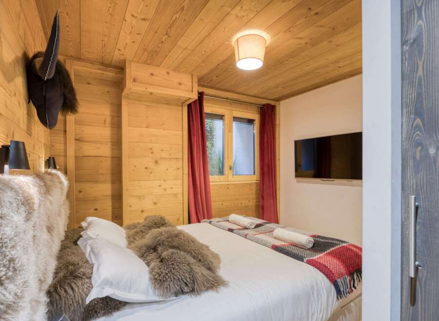 This cozy bedroom features a rustic wooden interior, creating a warm and inviting atmosphere.