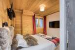 This cozy bedroom features a rustic wooden interior, creating a warm and inviting atmosphere.