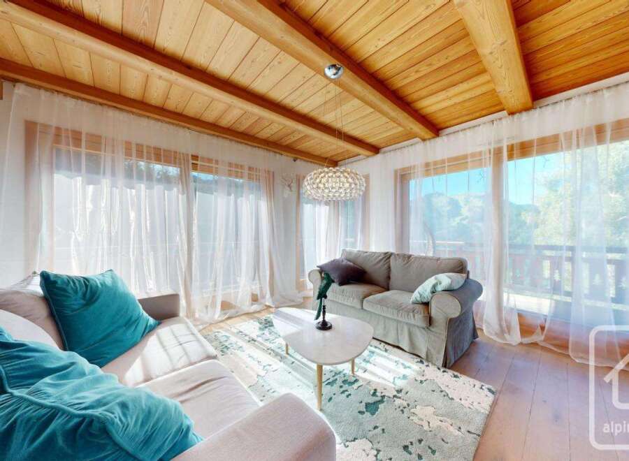 Experience luxury living in this stunning property, featuring a cozy living room with a plush sofa and vibrant teal cushions.