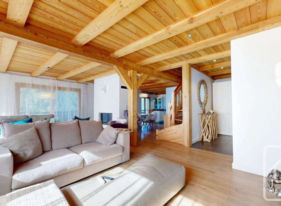 Experience the warmth of this stunning property, featuring a beautifully designed living space with exposed wooden beams and a cozy fireplace.