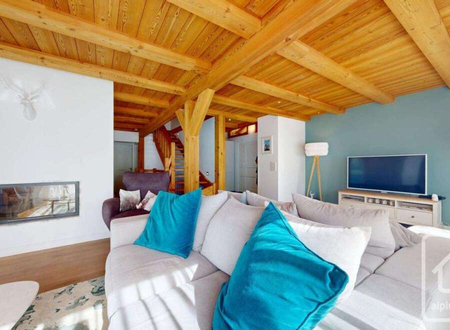 Experience the charm of this stunning property, featuring a cozy living room with a fireplace and a beautiful wooden ceiling.