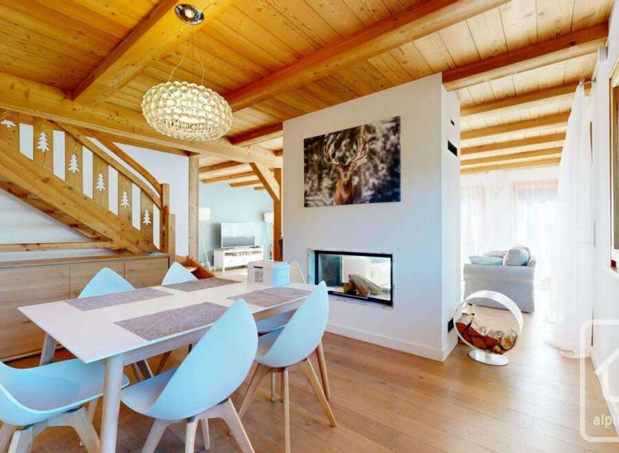 Experience luxury living in this stunning property, featuring a modern fireplace and a stylish dining area.