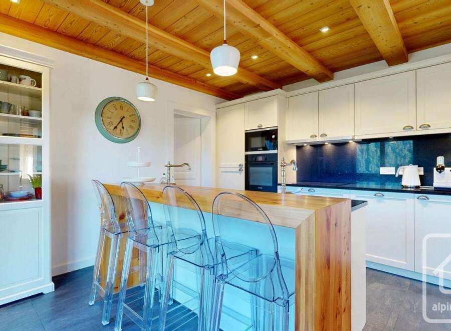 This stunning kitchen boasts a warm and inviting atmosphere with its wooden ceiling and modern design.