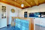 This stunning kitchen boasts a warm and inviting atmosphere with its wooden ceiling and modern design.