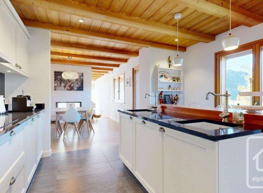 Experience the charm of this stunning kitchen, featuring a beautiful wooden ceiling and modern white cabinetry.