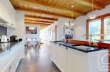 Experience the charm of this stunning kitchen, featuring a beautiful wooden ceiling and modern white cabinetry.