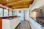 This stunning kitchen boasts a modern design with a touch of rustic charm, featuring wooden beams and sleek countertops.