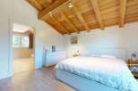 This stunning bedroom features a beautiful wooden ceiling and a cozy bed, creating a warm and inviting atmosphere.