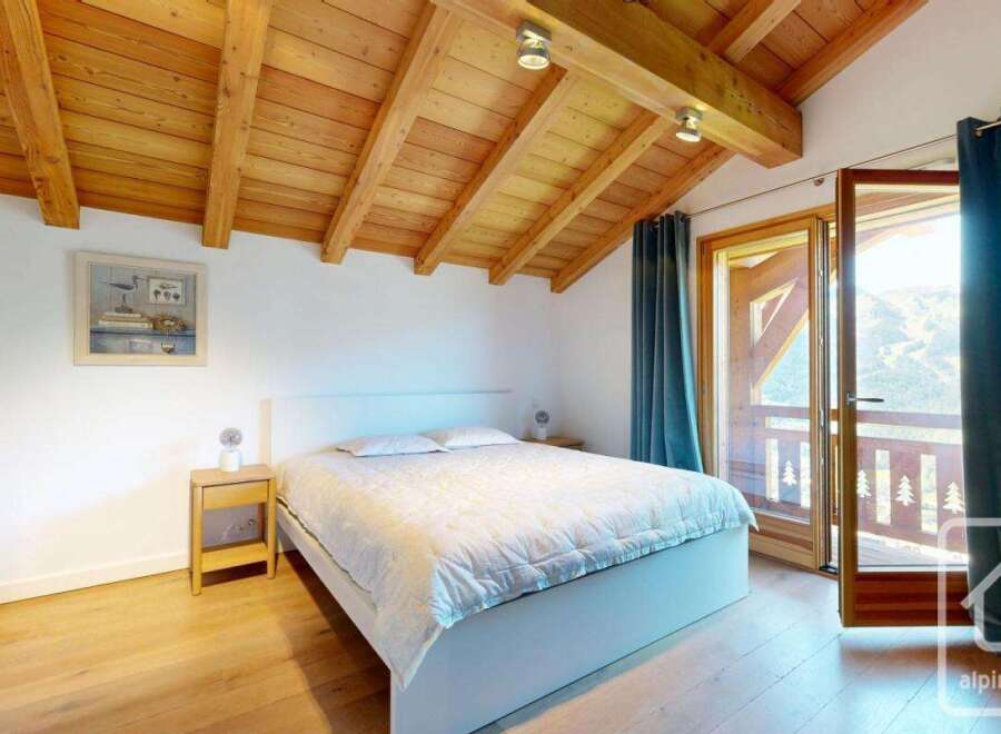 Experience the charm of this stunning bedroom, featuring a cozy bed and a beautiful wooden ceiling.