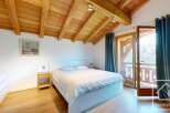Experience the charm of this stunning bedroom, featuring a cozy bed and a beautiful wooden ceiling.