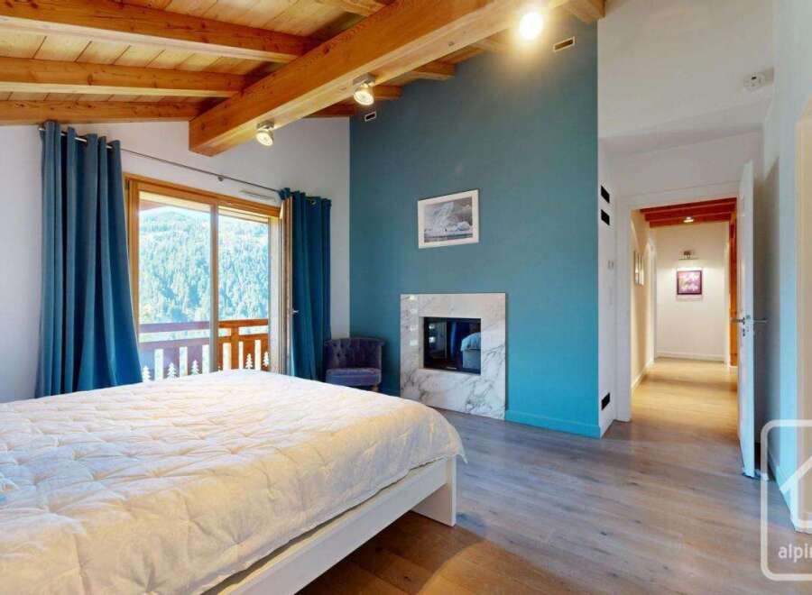 Discover this stunning property featuring a cozy bedroom with a fireplace and a comfortable bed.