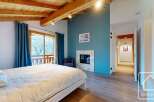 Discover this stunning property featuring a cozy bedroom with a fireplace and a comfortable bed.