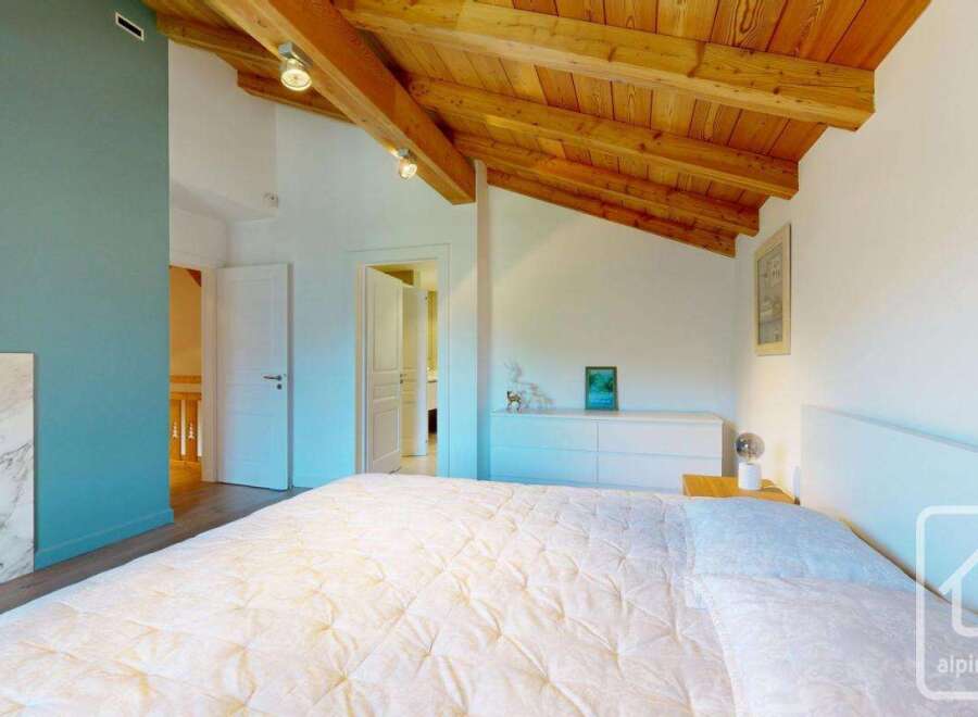 Experience the charm of this stunning bedroom featuring a cozy fireplace and a beautiful wooden ceiling.