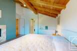 Experience the charm of this stunning bedroom featuring a cozy fireplace and a beautiful wooden ceiling.