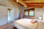 This charming bedroom features a cozy atmosphere with floral wallpaper and wooden beams.