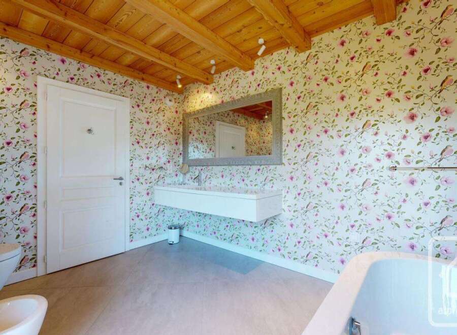 This charming bathroom features a unique floral wallpaper, creating a fresh and inviting atmosphere.