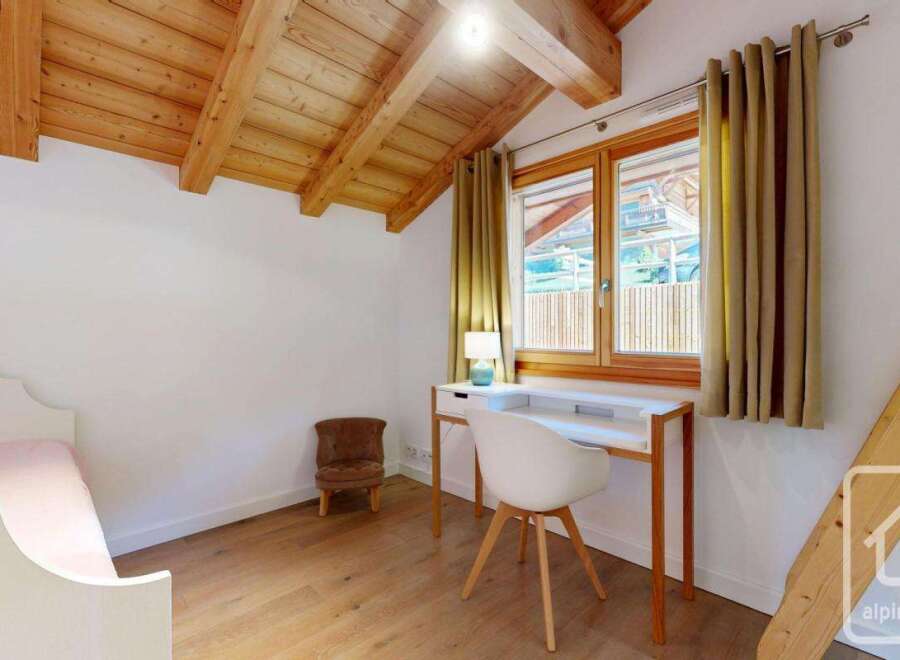 Discover the charm of this cozy bedroom, featuring a unique wooden ceiling and a bright, inviting atmosphere.