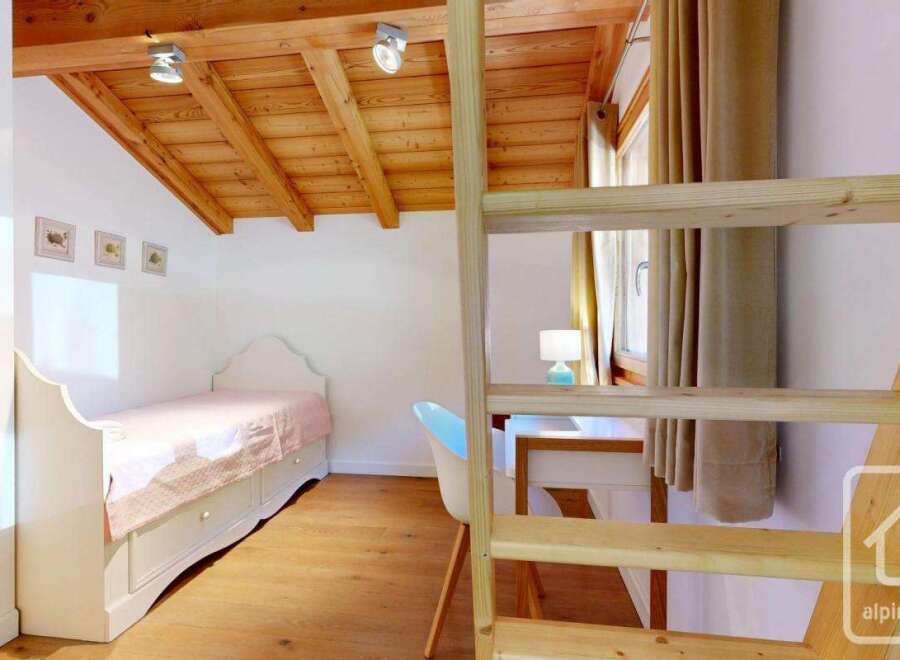 Discover the charm of this cozy bedroom, featuring a unique wooden ceiling and a comfortable bed.