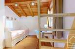 Discover the charm of this cozy bedroom, featuring a unique wooden ceiling and a comfortable bed.