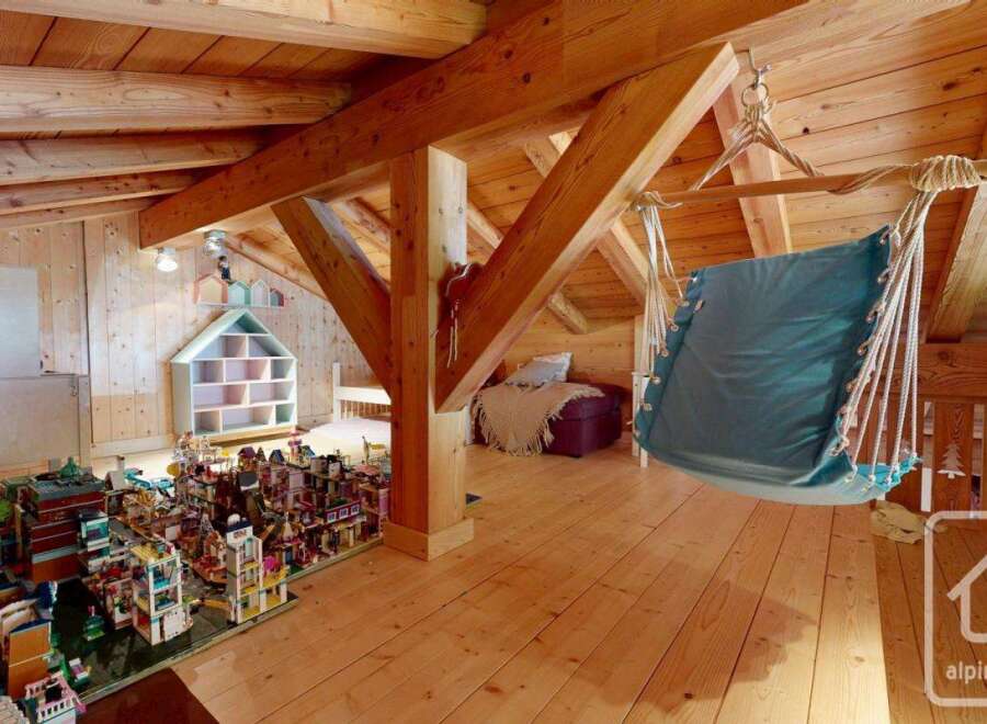 Discover the charm of this unique property, featuring a cozy attic space with exposed wooden beams and a relaxing hammock.