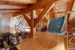 Discover the charm of this unique property, featuring a cozy attic space with exposed wooden beams and a relaxing hammock.