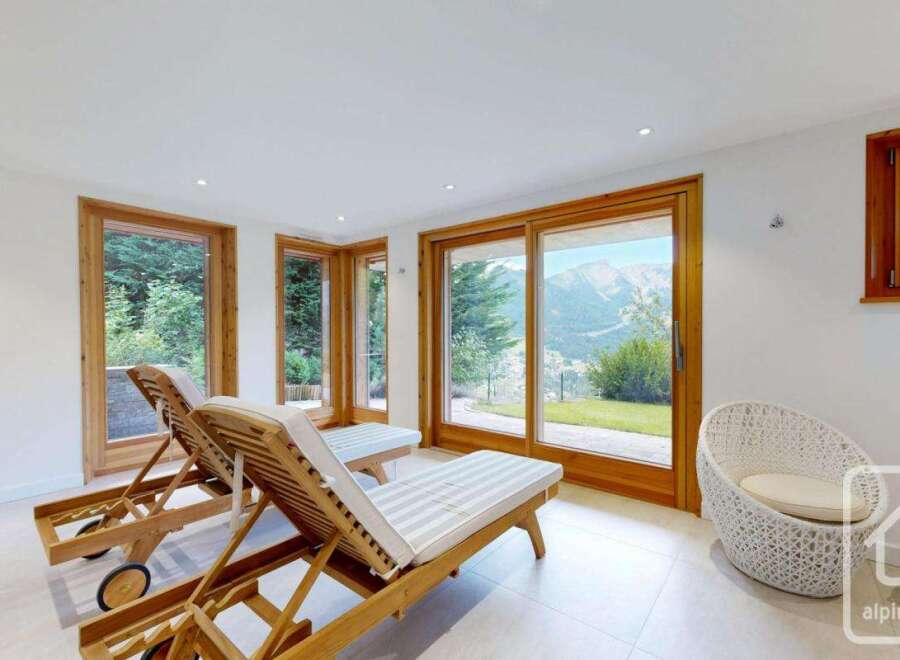 Relax and unwind in this stunning property, featuring breathtaking mountain views visible through expansive windows.