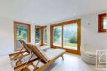 Relax and unwind in this stunning property, featuring breathtaking mountain views visible through expansive windows.