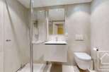 This modern bathroom features a sleek, minimalist design with neutral-toned tiles and a floating vanity.