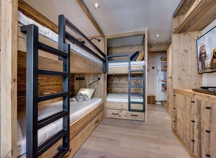 This cozy bedroom features custom-built bunk beds with a rustic wooden design, perfect for a family or group of friends.