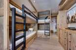 This cozy bedroom features custom-built bunk beds with a rustic wooden design, perfect for a family or group of friends.