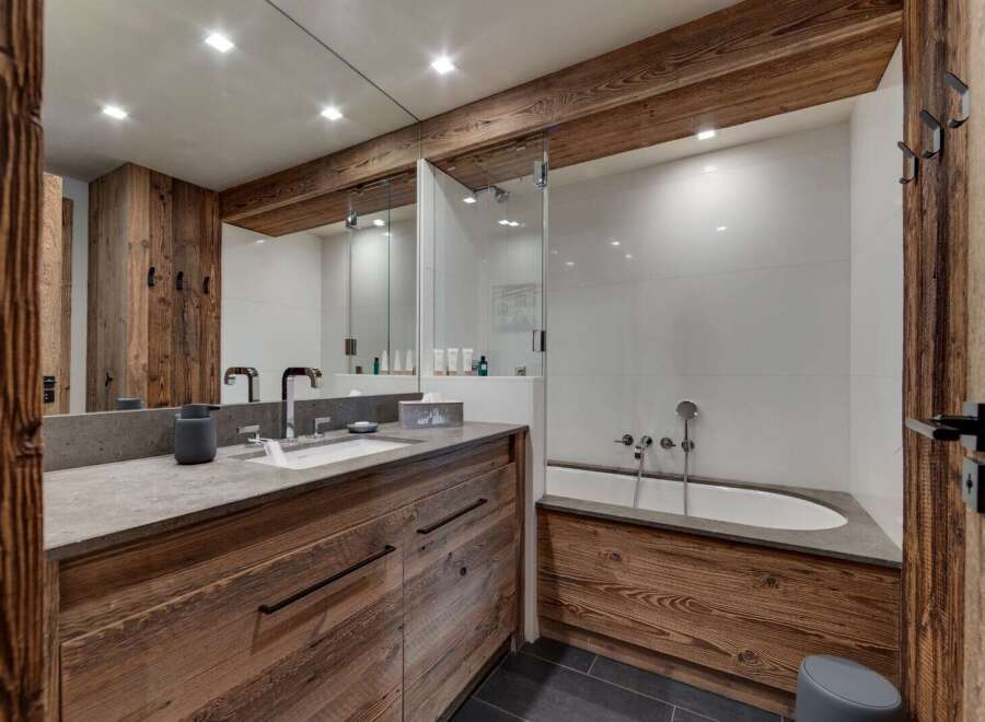 This luxurious bathroom features a stunning wooden vanity and a sleek, modern design.