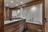 This luxurious bathroom features a stunning wooden vanity and a sleek, modern design.