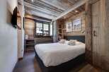 Experience rustic charm in this cozy bedroom, featuring stunning wood paneling and a comfortable bed.