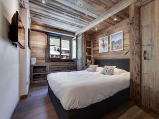 Experience rustic charm in this cozy bedroom, featuring stunning wood paneling and a comfortable bed.