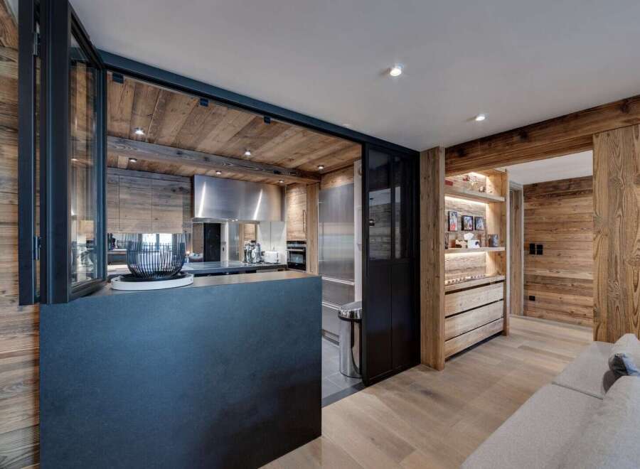 Experience rustic elegance in this stunning property, featuring a beautifully designed kitchen with wood paneling and modern appliances.