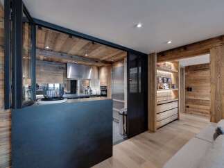 Experience rustic elegance in this stunning property, featuring a beautifully designed kitchen with wood paneling and modern appliances.