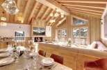 Experience luxury living in this stunning chalet, featuring a cozy fireplace and a spacious living area.